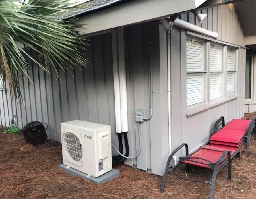 Exterior view of ductless mini-split HVAC system installed on a coastal home, showcasing professional heating and air conditioning service with Mitsubishi Electric unit.